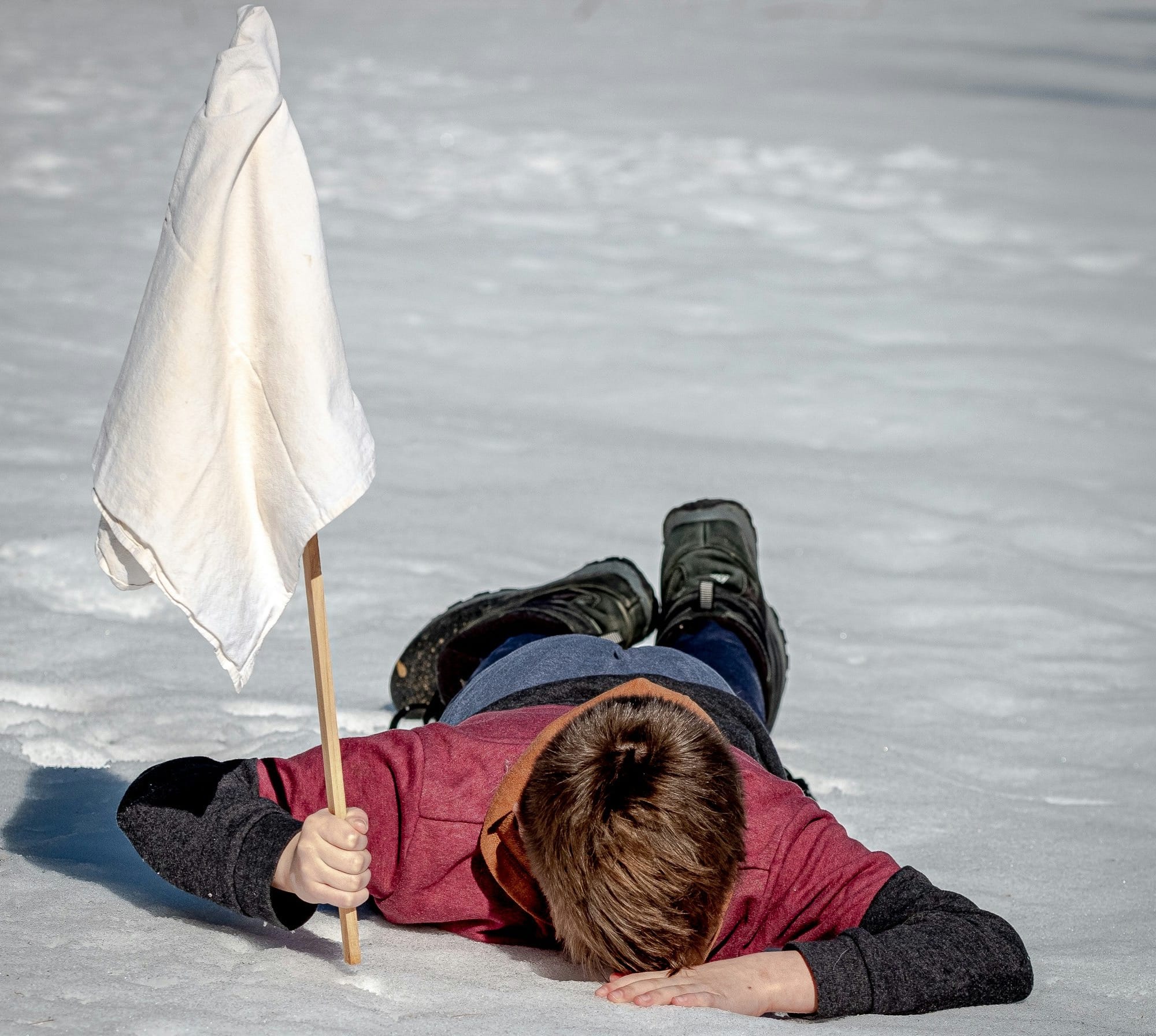 woman in black jacket lying on white snow